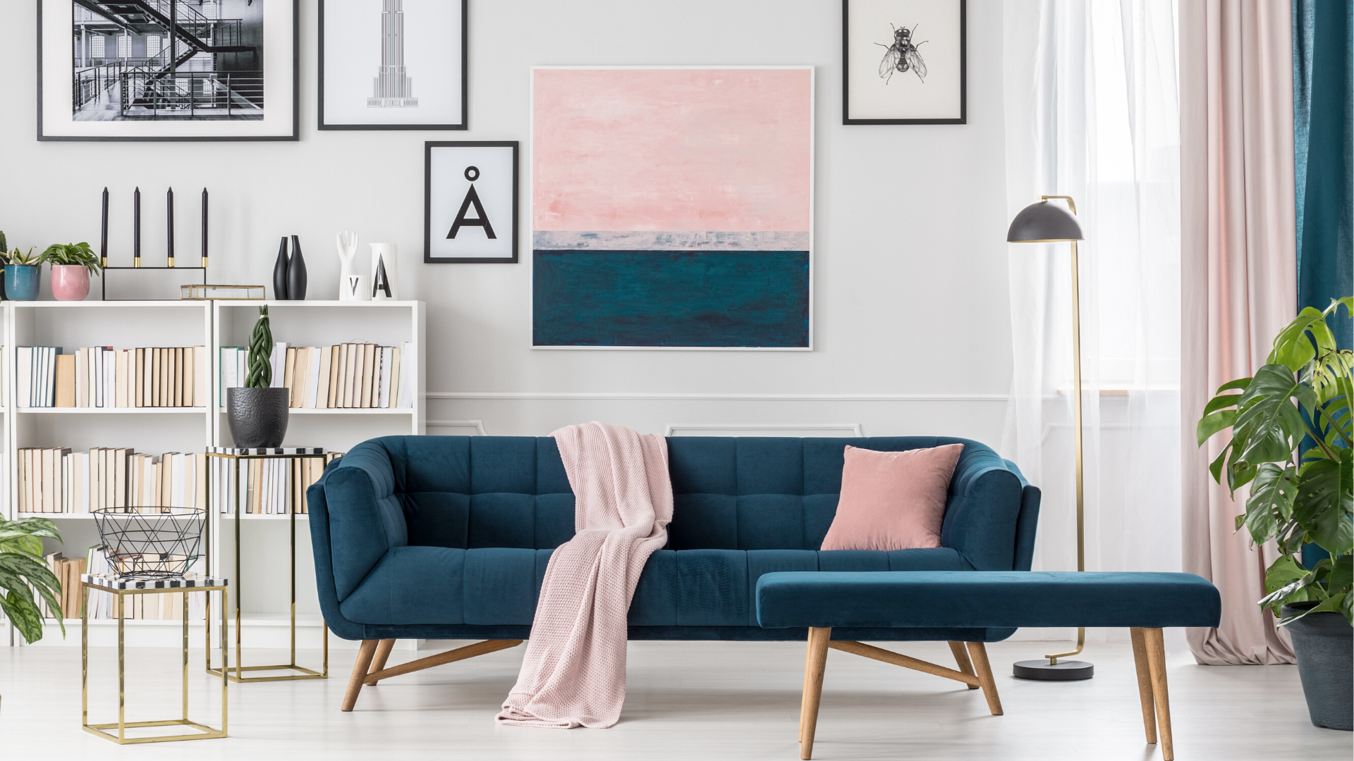 H&M Home interior with a blue sofa, pink throw and framed wall art.